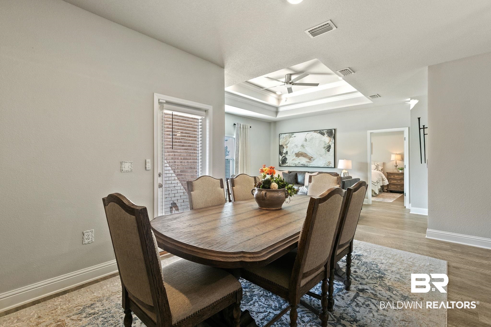 31650 Memphis Loop Daphne, AL 36527 - Photo 17 of 68 Dining area featuring a raised ceiling, wood finished floors, and ceiling fan