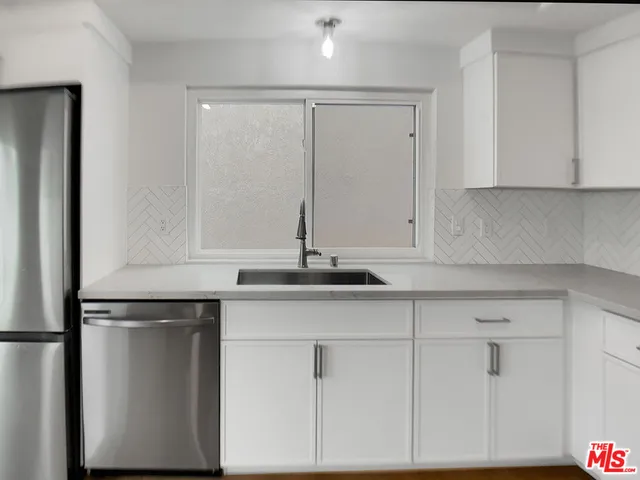 a kitchen with granite countertop white cabinets and a sink