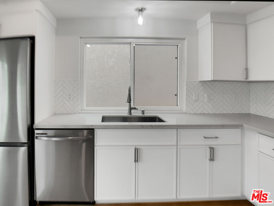 953 South Ridgecrest Circle Anaheim, CA 92807 - Photo 14 of 26 a kitchen with granite countertop white cabinets and a sink