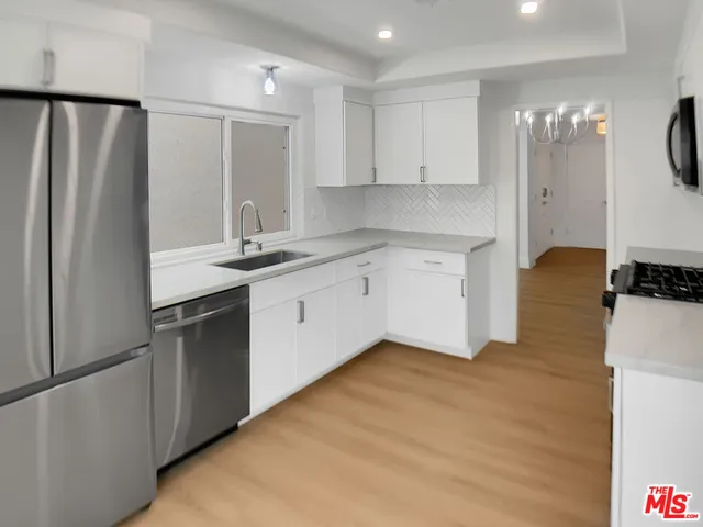 a kitchen with stainless steel appliances a refrigerator sink and cabinets
