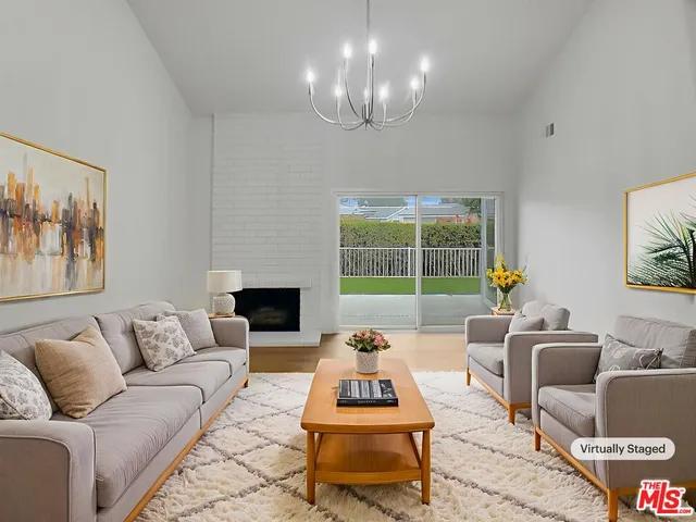 a living room with furniture fireplace and a large window