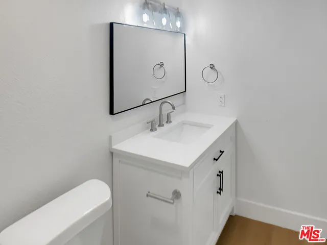 a bathroom with a sink a toilet and mirror