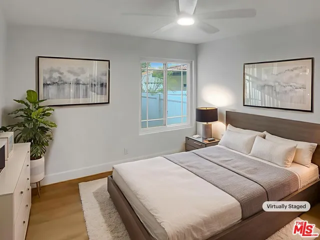 a bedroom with a large bed and a potted plant