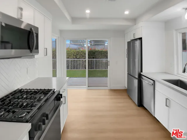 a kitchen with stainless steel appliances a stove a microwave and a refrigerator