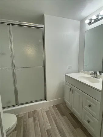 a bathroom with a granite countertop sink toilet and shower