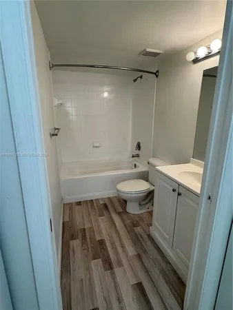 a bathroom with a sink a toilet a mirror and shower