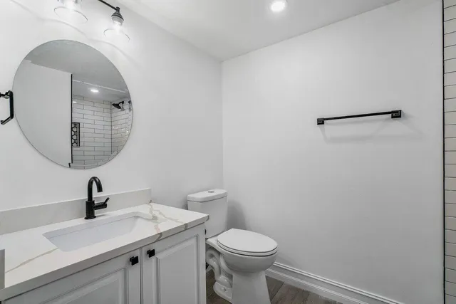 a bathroom with a toilet a sink and mirror