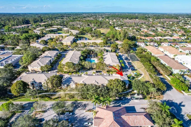 an aerial view of residential houses with outdoor space and trees