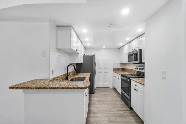 a kitchen with stainless steel appliances granite countertop a sink stove and refrigerator