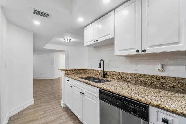 a kitchen with granite countertop a sink and cabinets