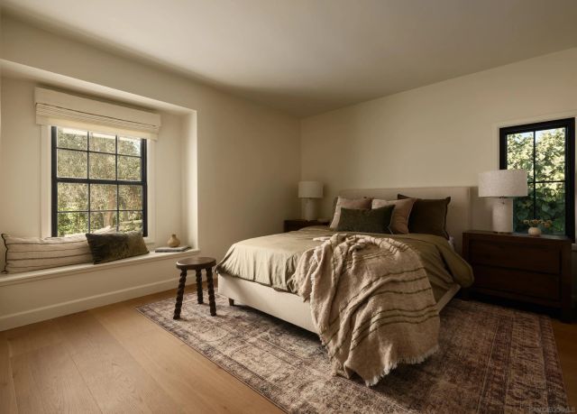 a bed sitting in a bedroom next to a window