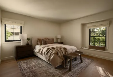 a bed sitting in a bedroom next to a window