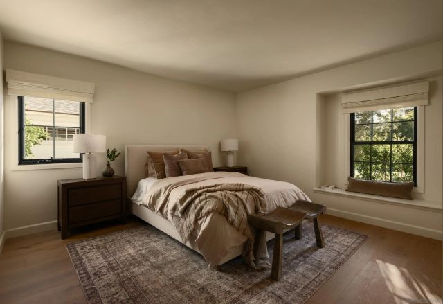 a bed sitting in a bedroom next to a window