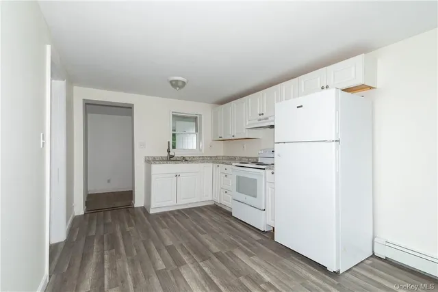 a kitchen with white cabinets and white appliances
