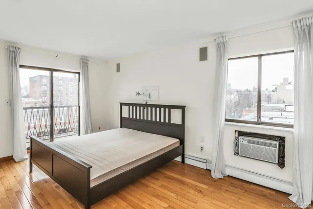 a large white bed sitting in a room next to a window