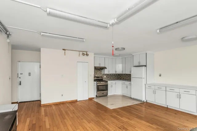 a kitchen with granite countertop a refrigerator and a sink