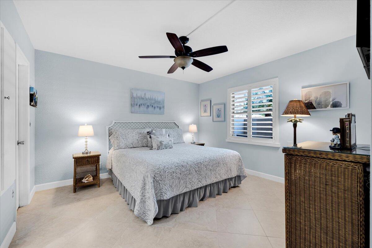 300 North Hwy A1A, Unit 104O Jupiter, FL 33477 - Photo 11 of 25 a bedroom with a bed and a chandelier
