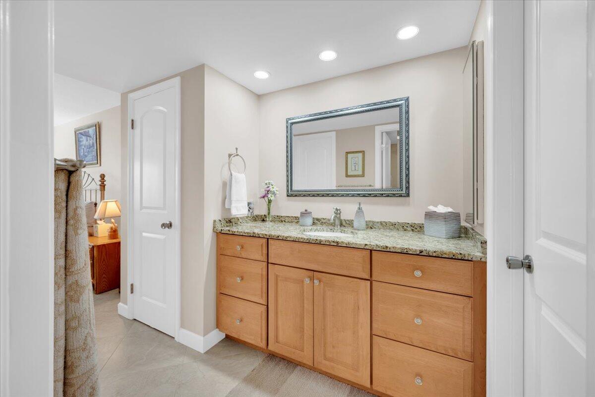 300 North Hwy A1A, Unit 104O Jupiter, FL 33477 - Photo 14 of 25 a bathroom with a granite countertop sink and a mirror