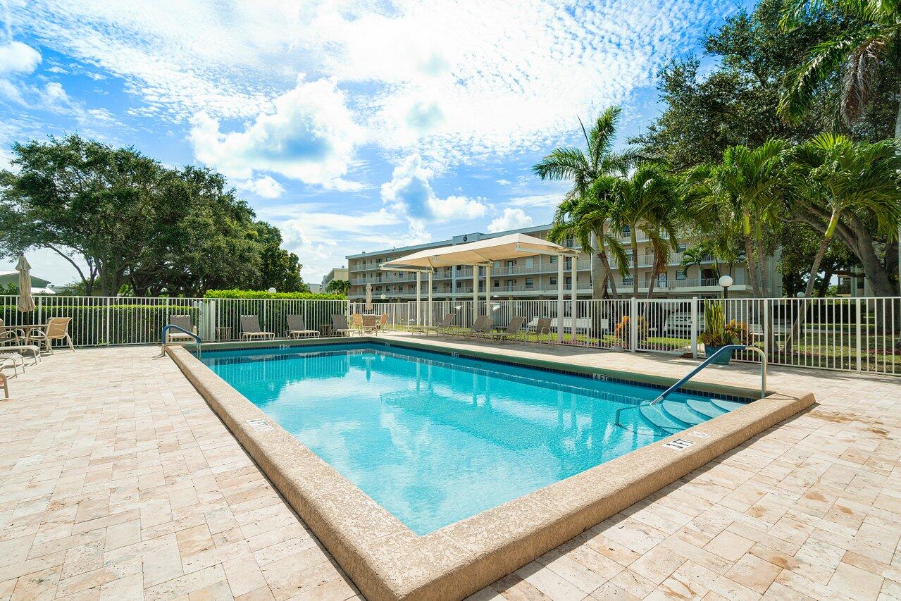 300 North Hwy A1A, Unit 104O Jupiter, FL 33477 - Photo 20 of 25 a view of a swimming pool with a lounge chair