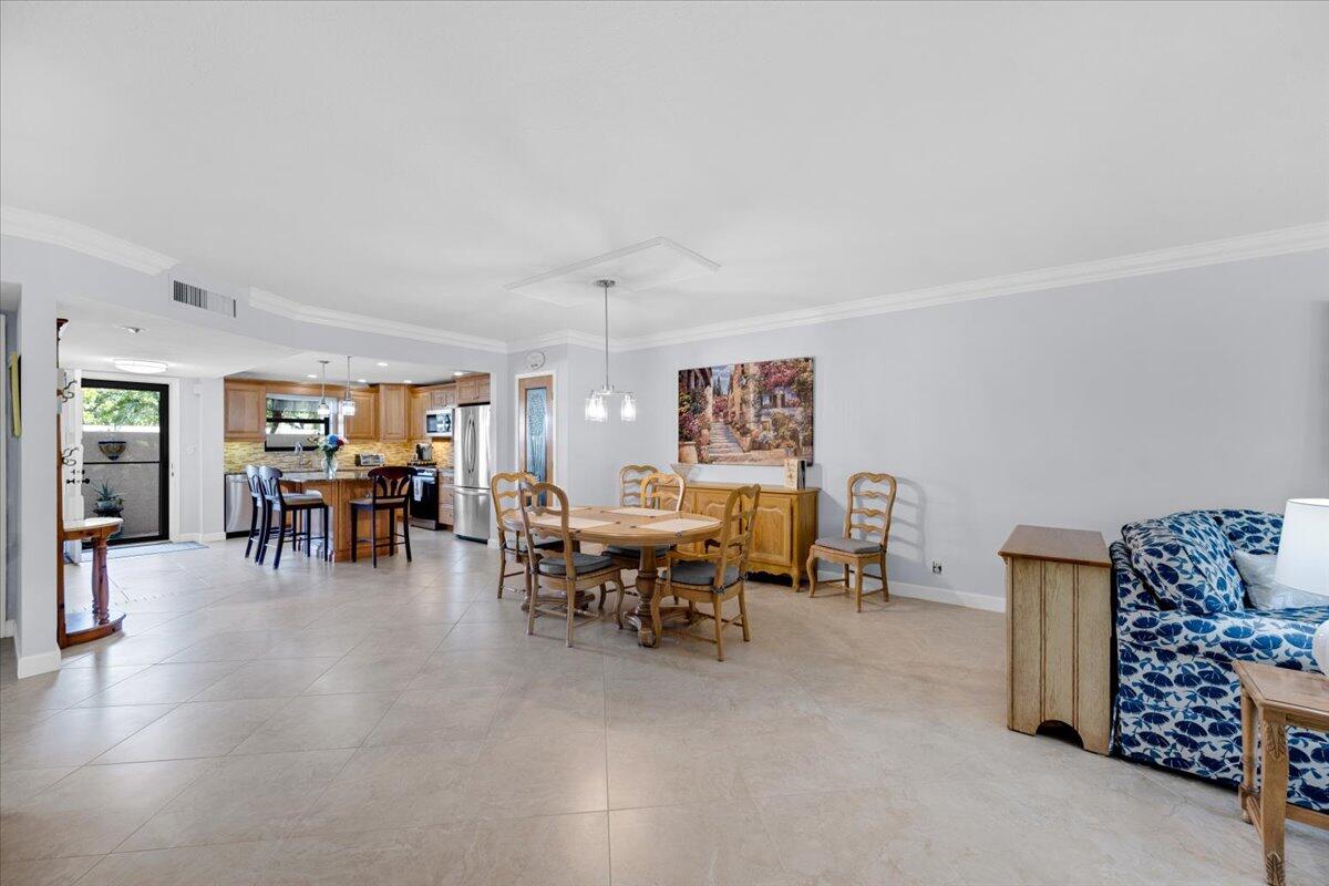 300 North Hwy A1A, Unit 104O Jupiter, FL 33477 - Photo 8 of 25 a view of a dining room with furniture and chandelier