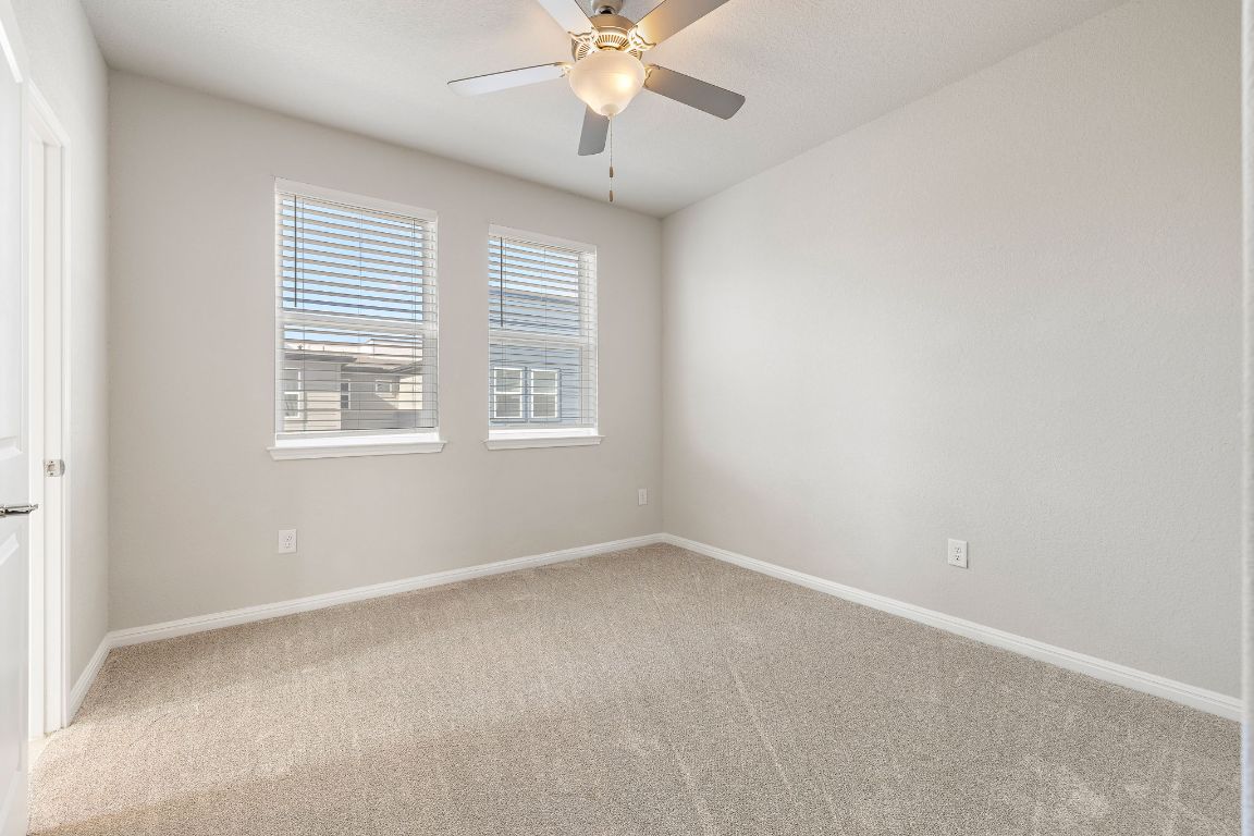 9015 Cattle Baron Path, Unit 504 Austin, TX 78747 - Photo 20 of 36 an empty room with windows and fan