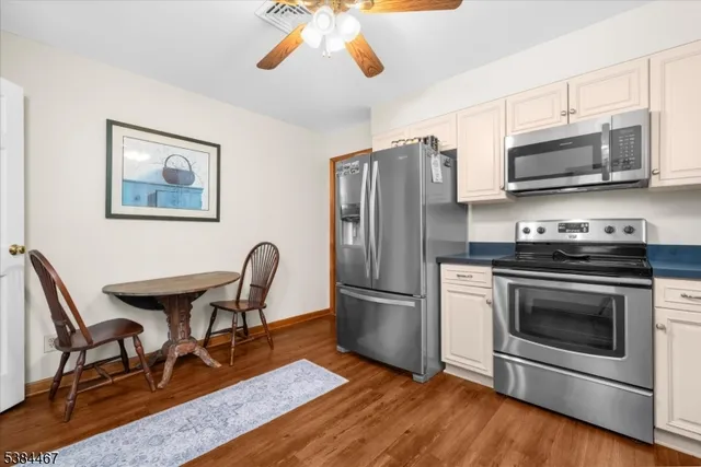 a kitchen with stainless steel appliances granite countertop a stove a microwave a sink dishwasher a refrigerator with a dining table and chair