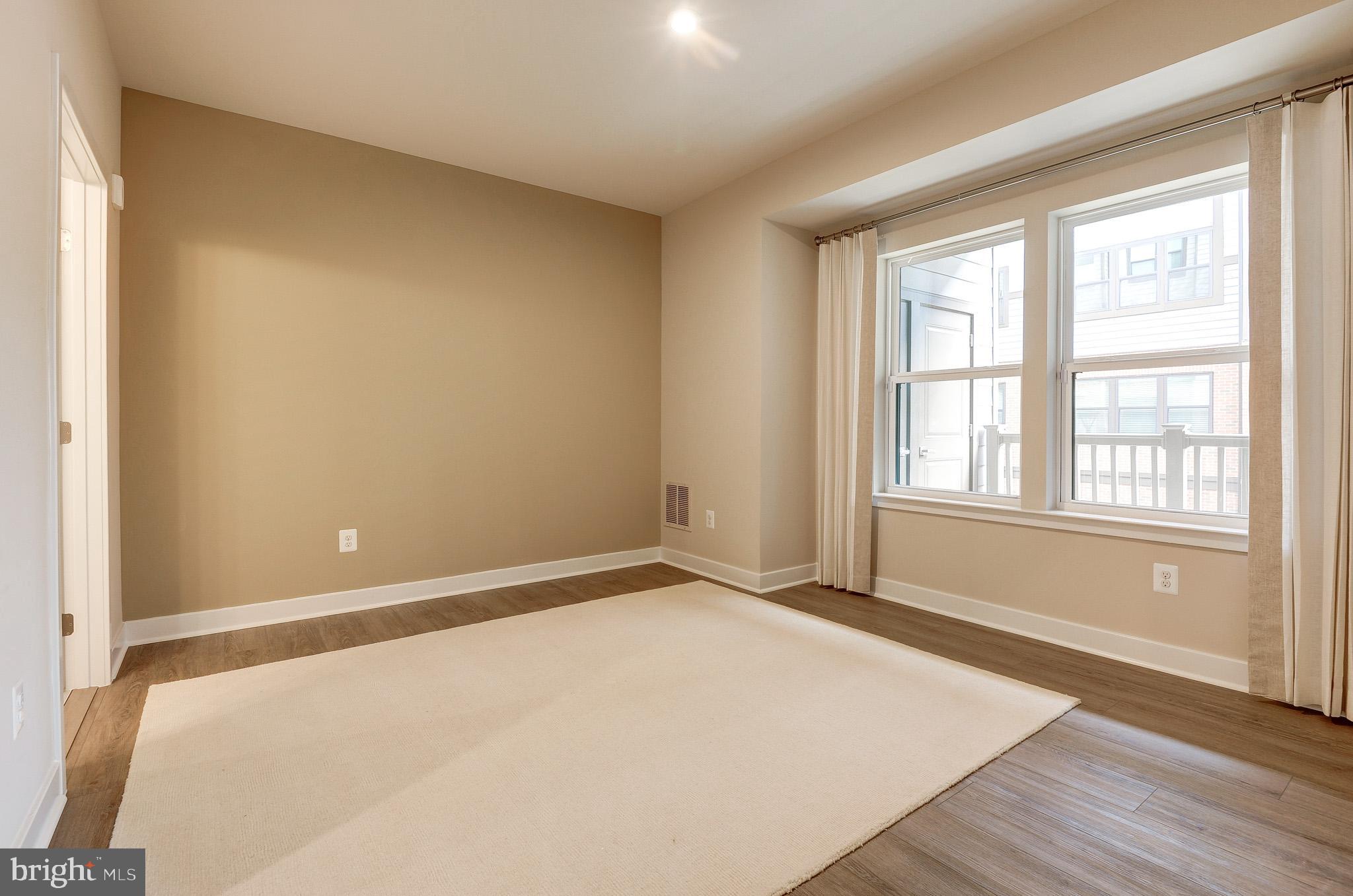 4395 Peach Lily Lane, Unit 304 Chantilly, VA 20151 - Photo 13 of 36 a view of an empty room with wooden floor and a window