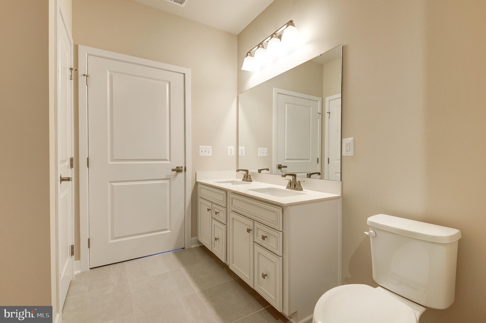 4395 Peach Lily Lane, Unit 304 Chantilly, VA 20151 - Photo 17 of 36 a bathroom with a toilet sink and mirror