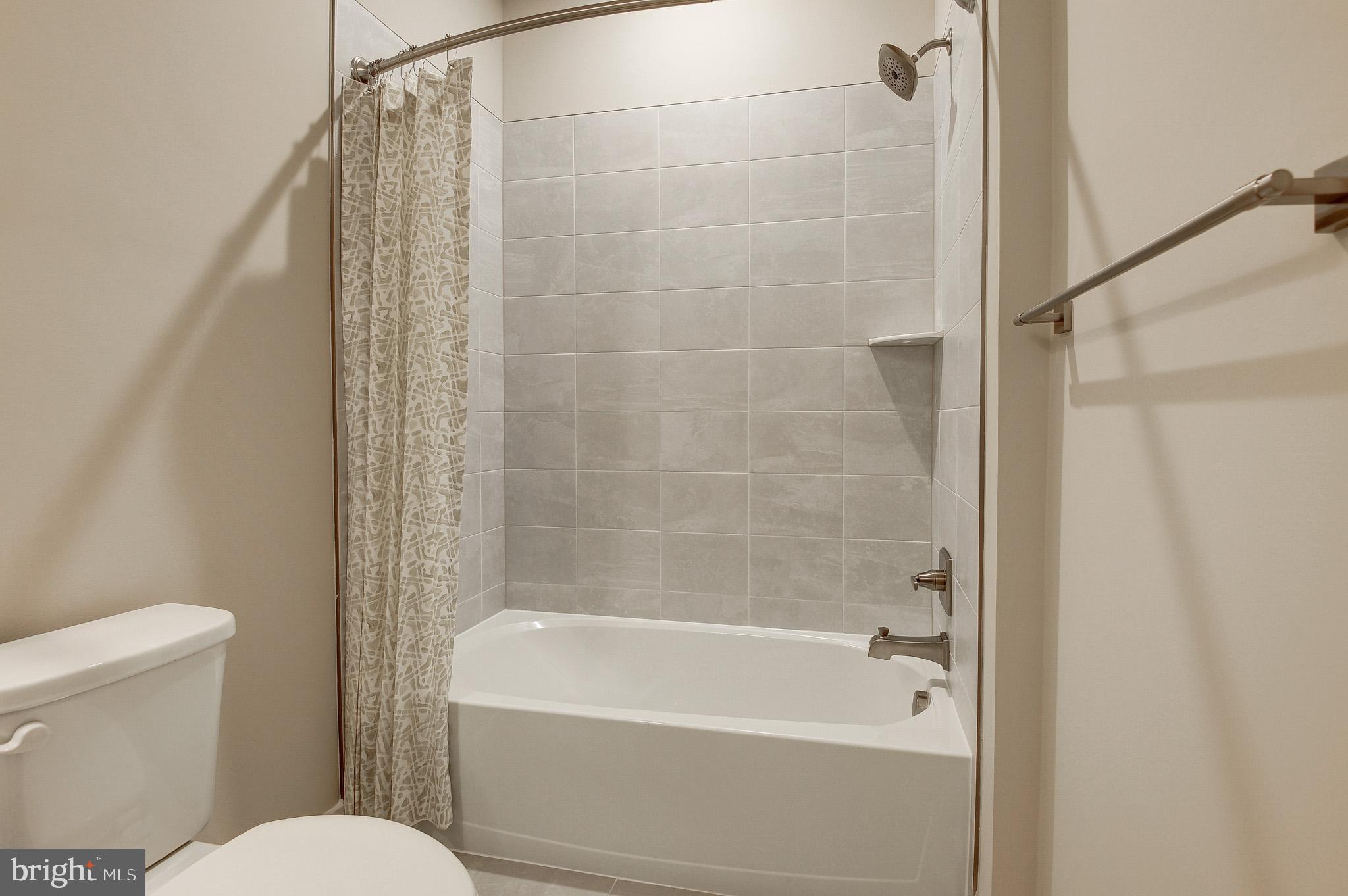 4395 Peach Lily Lane, Unit 304 Chantilly, VA 20151 - Photo 24 of 36 a bath room with a toilet and a bath tub