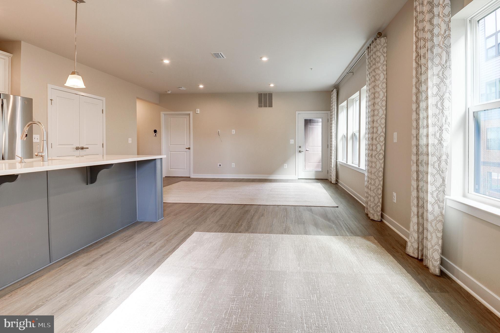 4395 Peach Lily Lane, Unit 304 Chantilly, VA 20151 - Photo 3 of 36 a view of a kitchen with kitchen island a sink wooden floor and a large window