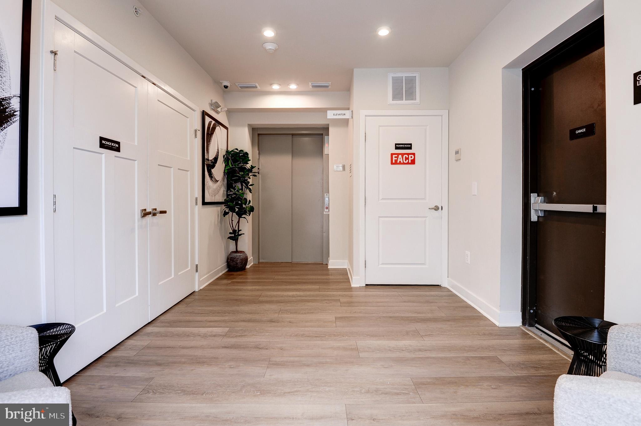 4395 Peach Lily Lane, Unit 304 Chantilly, VA 20151 - Photo 32 of 36 a view of a hallway with wooden floor and closet