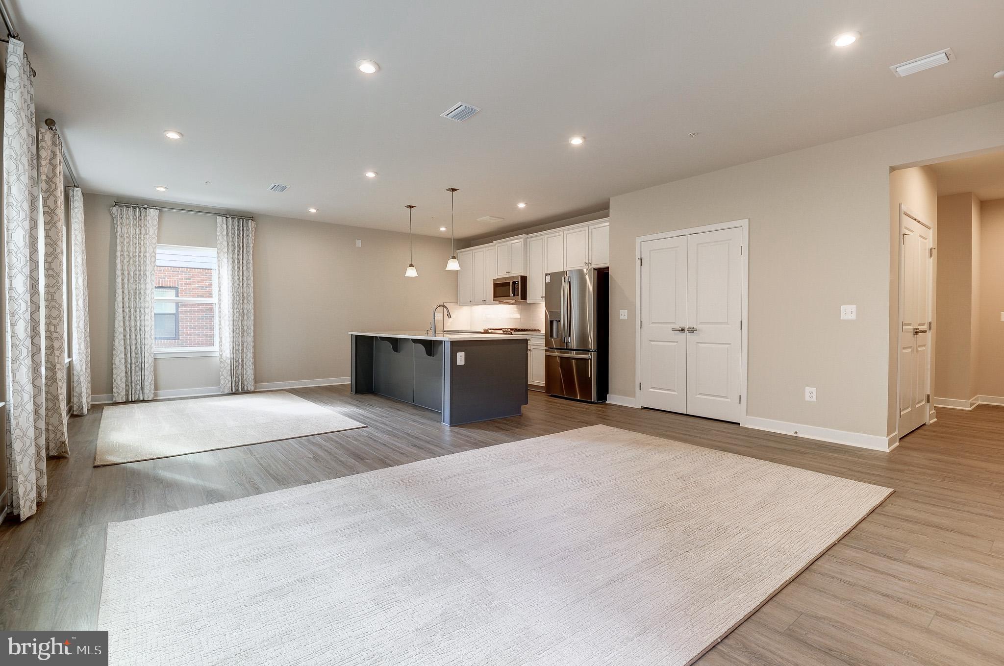 4395 Peach Lily Lane, Unit 304 Chantilly, VA 20151 - Photo 7 of 36 a large space with stainless steel appliances kitchen island a sink granite counter tops and a large window