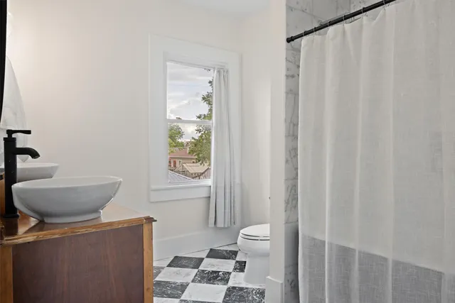 a bath room with a toilet a sink and a shower