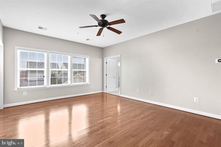 23215 Frederick Road Clarksburg, MD 20871 - Photo 15 of 31 a view of wooden floor and a chandelier fan in a room
