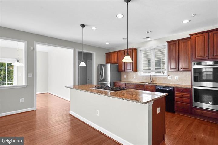 23215 Frederick Road Clarksburg, MD 20871 - Photo 4 of 31 a large kitchen with granite countertop a sink a counter space appliances and cabinets