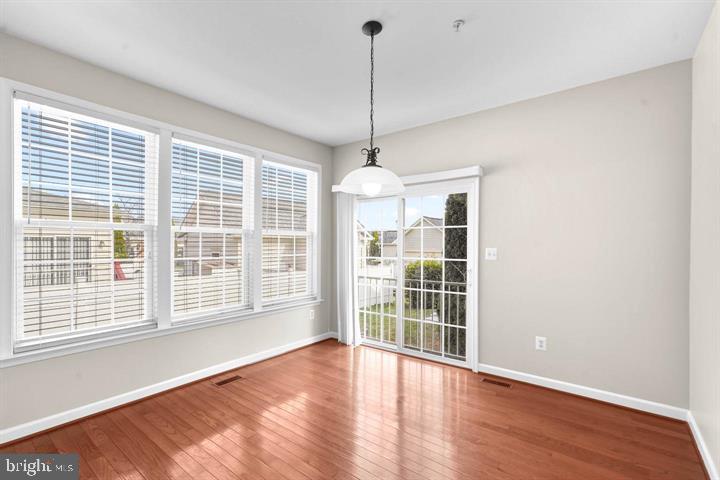 23215 Frederick Road Clarksburg, MD 20871 - Photo 7 of 31 a view of an empty room with a window and wooden floor