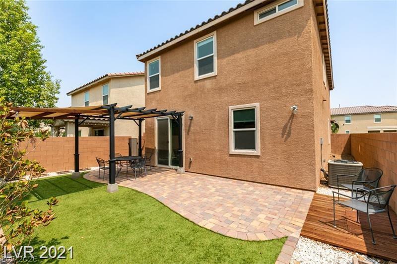 5475 Ordesa Valley Road Las Vegas, NV 89148 - Photo 8 of 35 An inviting backyard retreat features a pergola-covered patio with pavers and lush artificial turf.