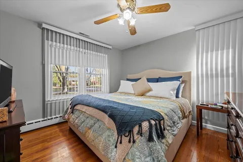 a bedroom with a bed and a flat tv screen on dresser