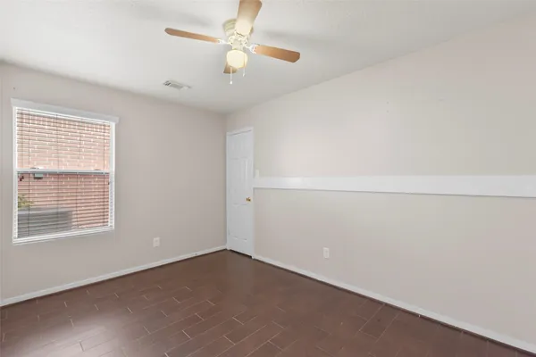 an empty room with a window and ceiling fan