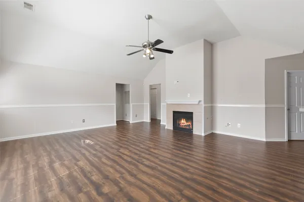 a view of empty room with wooden floor fireplace and window
