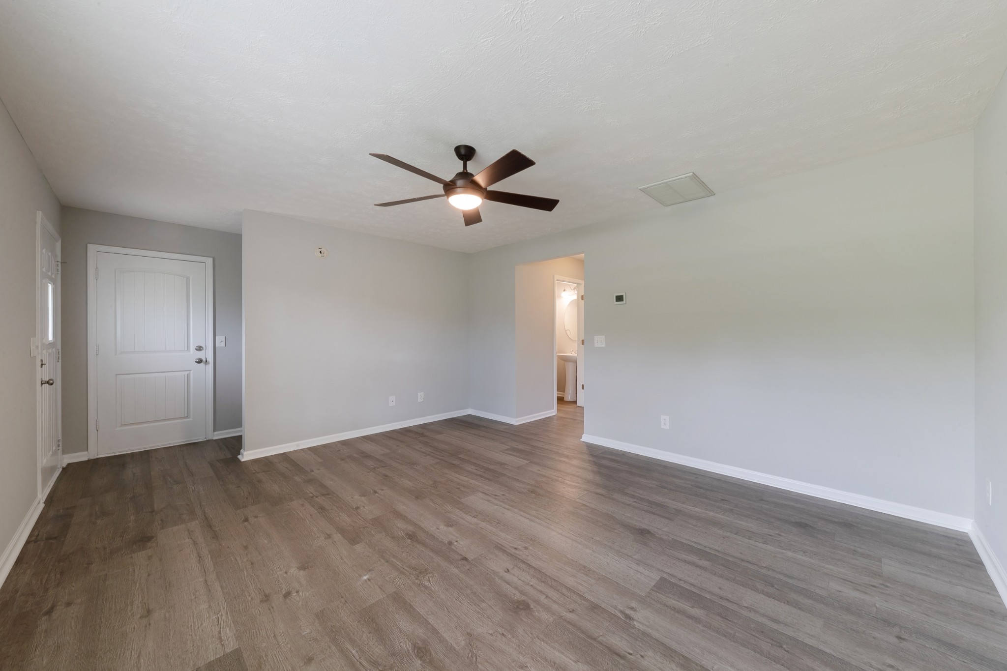 921 Woodall Road Lebanon, TN 37090 - Photo 7 of 30 a view of an empty room with wooden floor and a ceiling fan