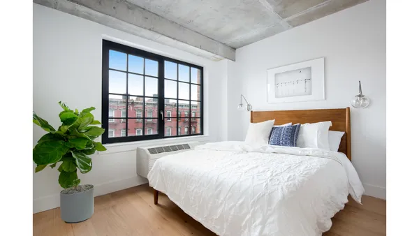 a bedroom with a bed and a potted plant