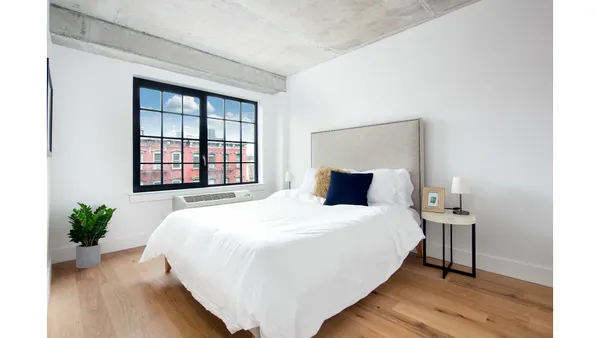 a bedroom with a bed and a potted plant