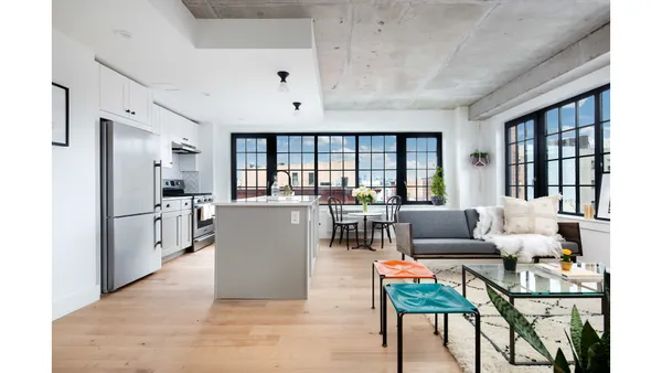 a living room with furniture and a dining table next to a window