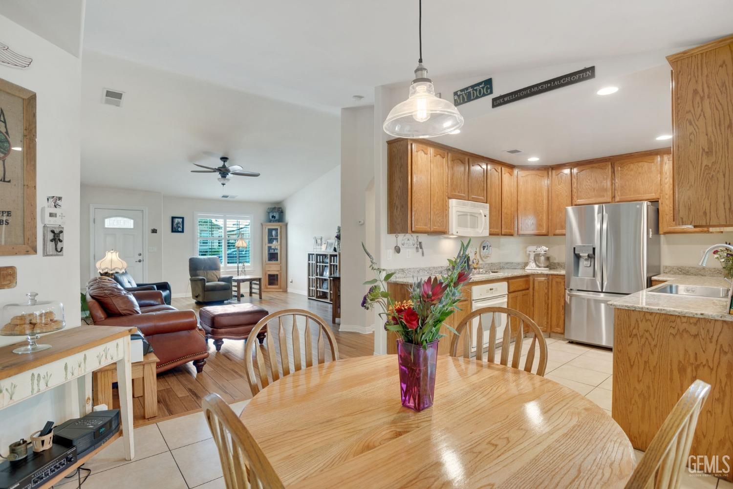 Undisclosed Address Taft, CA 93268 - Photo 26 of 60 a kitchen with stainless steel appliances kitchen island granite countertop a dining table chairs and white cabinets