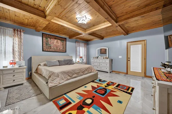 a spacious bedroom with a bed and a dresser in it