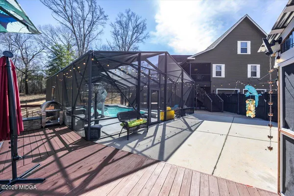 a view of a roof deck with table and chairs under an umbrella with wooden floor