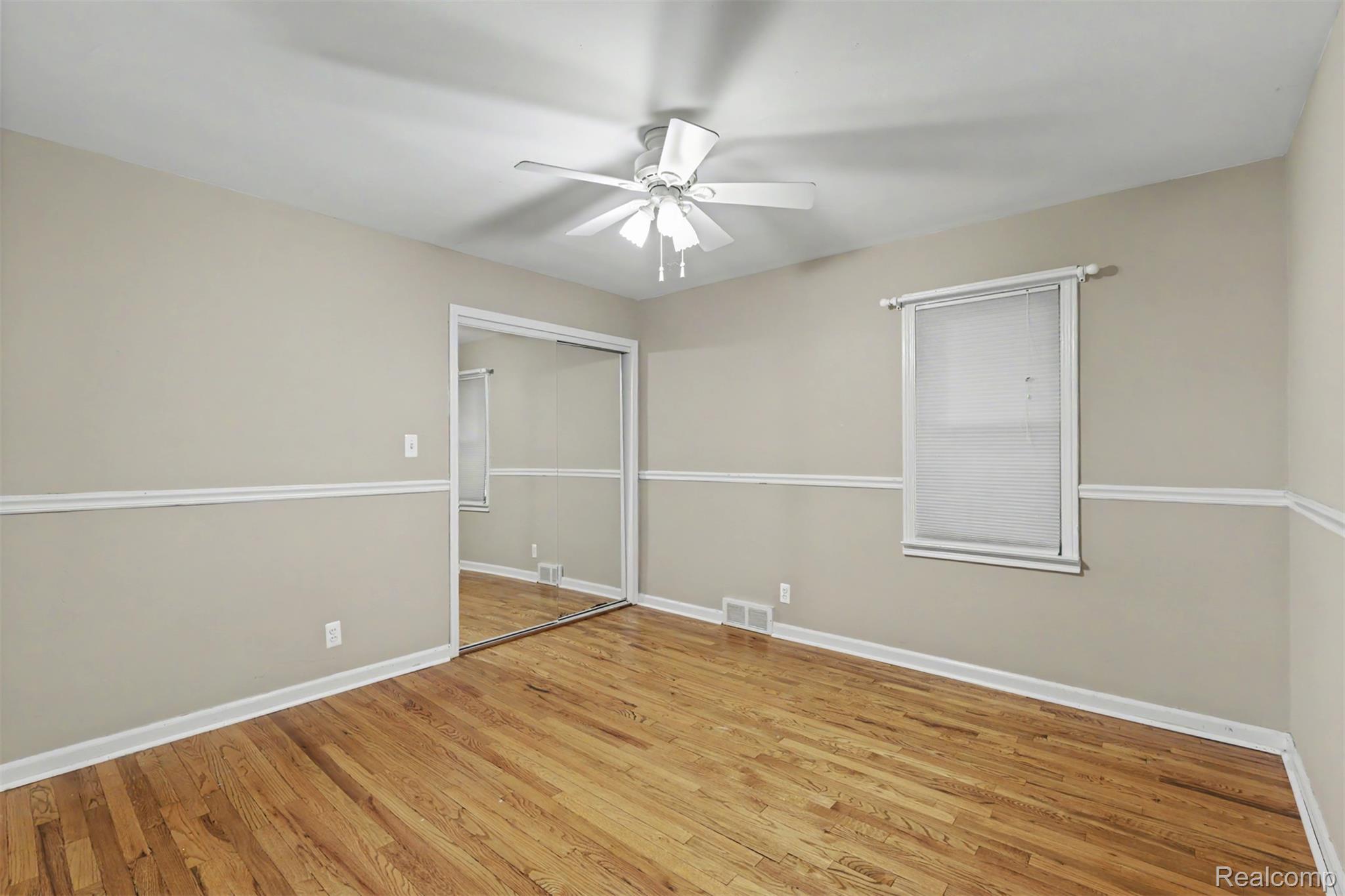 7136 Rosedale Boulevard Allen Park, MI 48101 - Photo 22 of 51 Hardwood flooring, mirrored closet doors, ceiling fan, and window with blinds