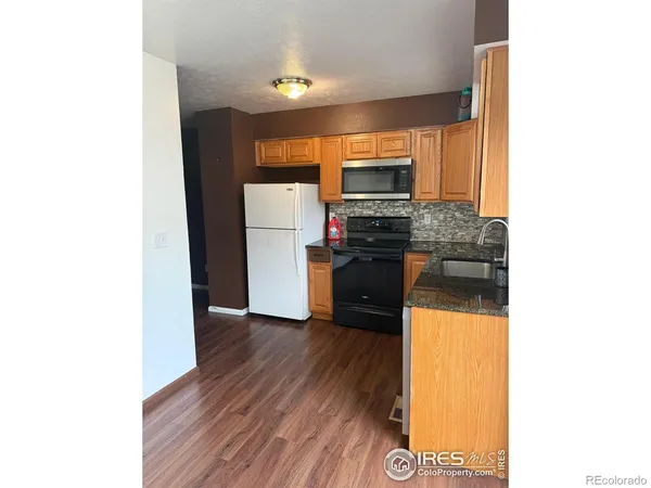 a kitchen with a refrigerator and a stove top oven