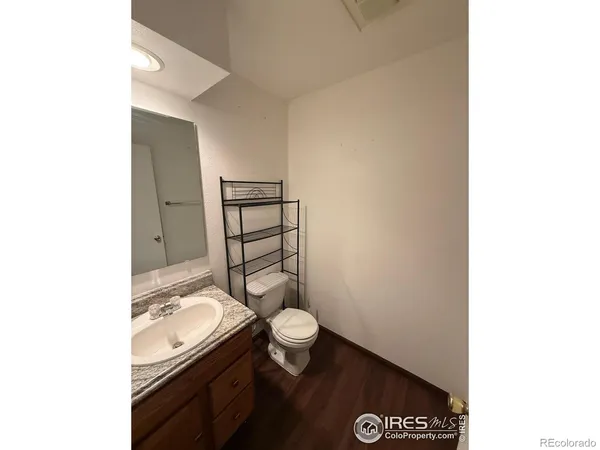 a bathroom with a granite countertop toilet and a sink